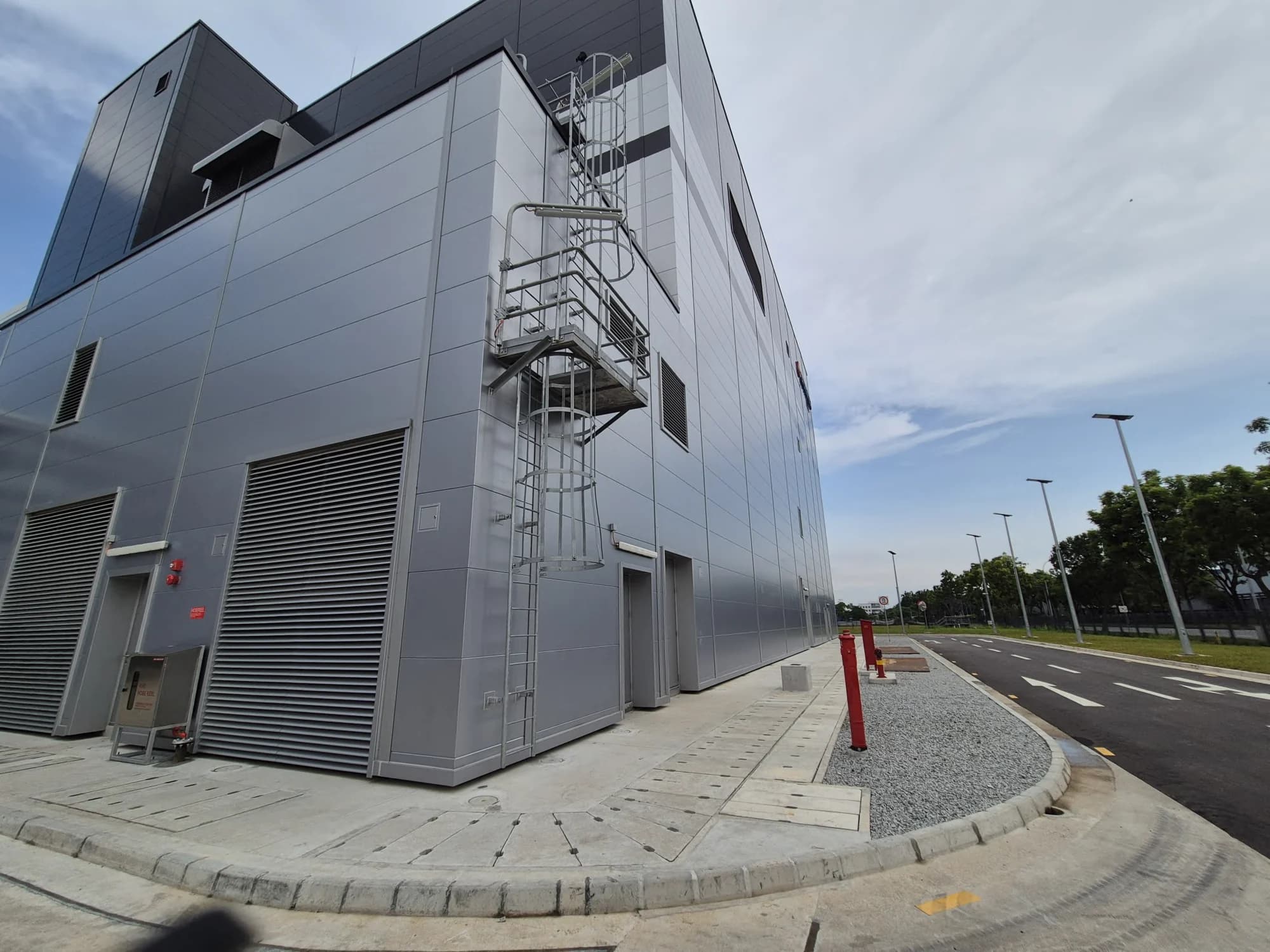 Street-corner view of the Novartis production building's metal-clad exterior