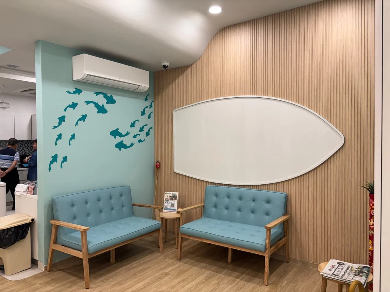 Marine-inspired waiting area with blue seating and fish motifs at NTUC Health Bedok